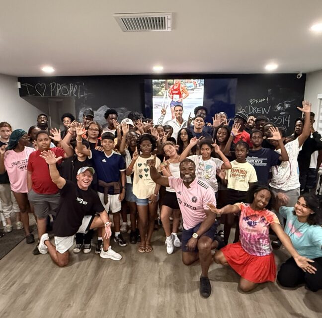 PROPEL students and mentors waving in a classroom