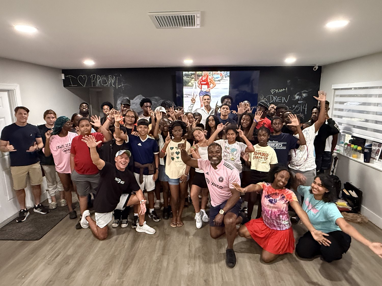 PROPEL students and mentors waving in a classroom