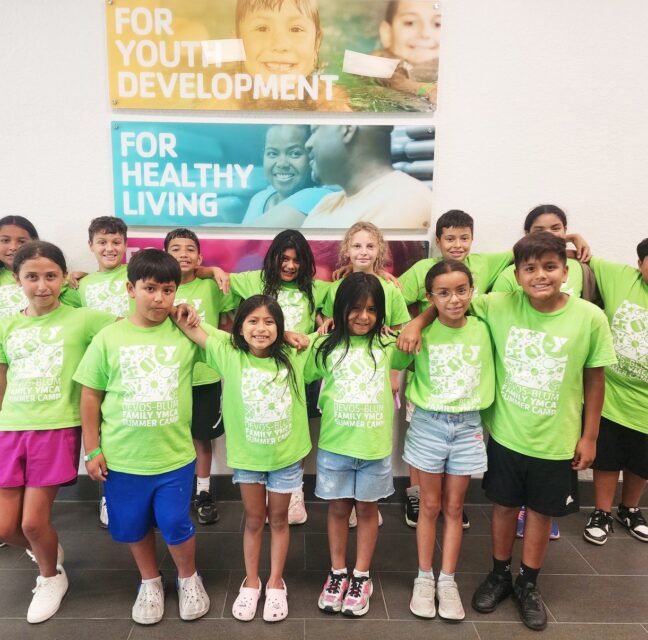 Children in green YMCA summer camp shirts at the Peter Blum Family YMCA