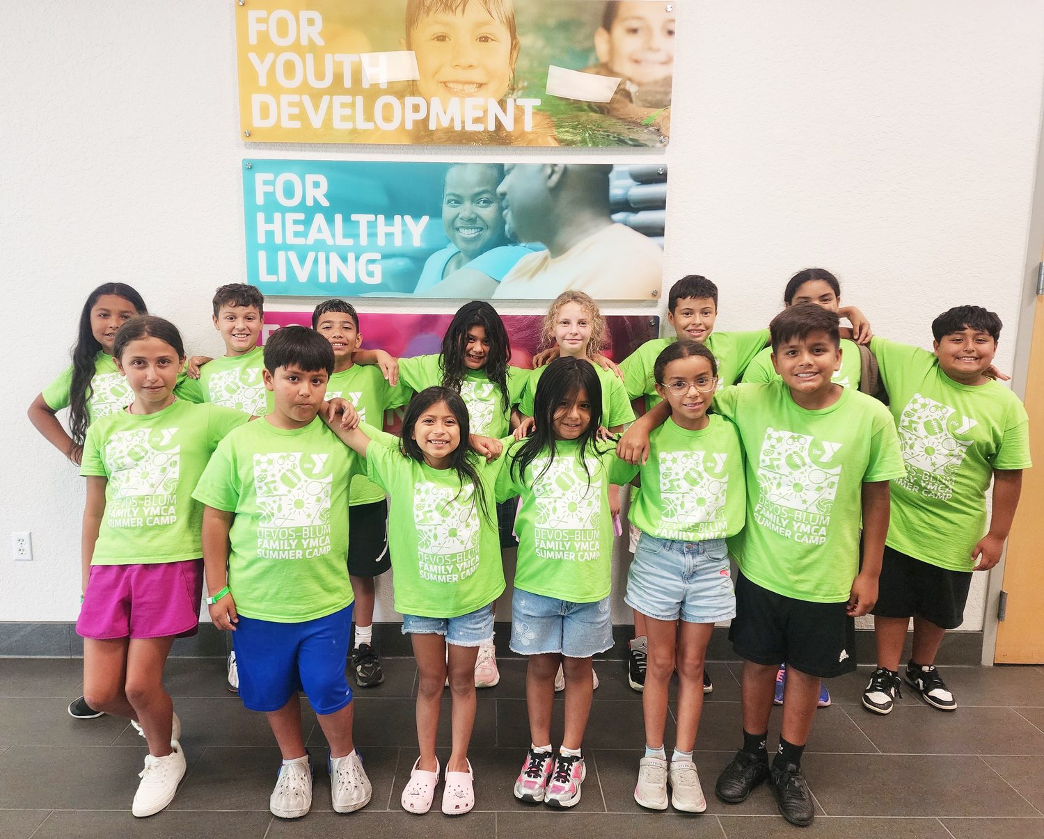 Children in green YMCA summer camp shirts at the Peter Blum Family YMCA