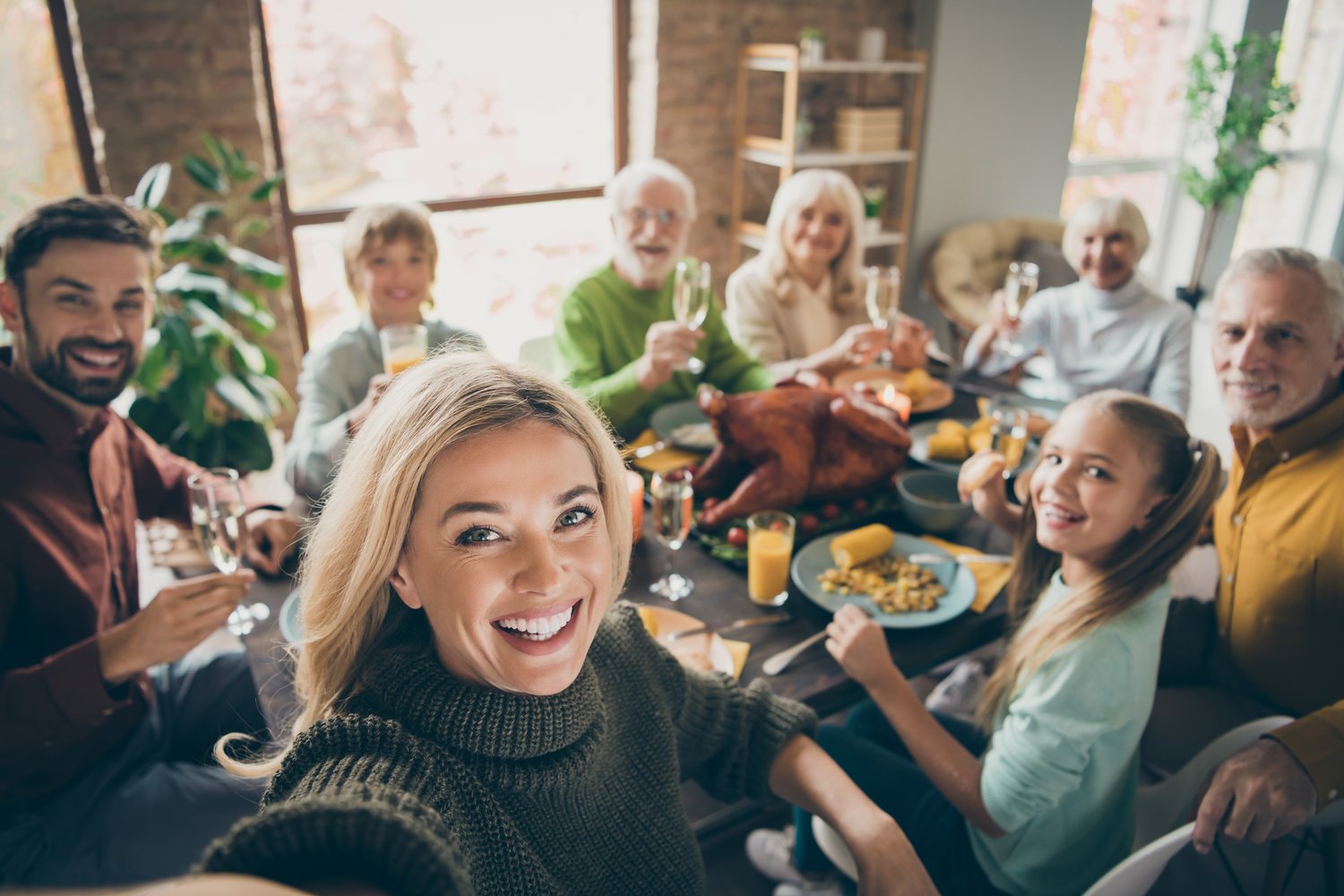 A family gathered around a Thanksgiving table raising glasses