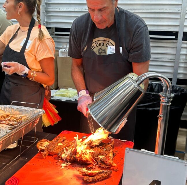 Volunteers carving turkey at the carved turkey station during the Thanksgiving banquet