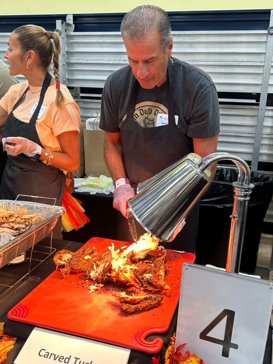 Volunteers carving turkey at the carved turkey station during the Thanksgiving banquet